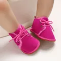 Detailed close-up of fuchsia pink baby fleece-lined winter boots with soft soles - Peach