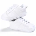 Vista detallada de zapatillas blancas para bebé con suela blanda y rayas decorativas - Todo Blanco