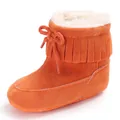 Close-up detail of orange infant winter snow boots with fringe and soft fur lining - Orange