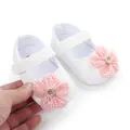 Detail van witte baby loopschoentjes met een roze geblokte bloem en een knoop - Wit Roze