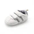 Detailed side view of white baby pre-walker shoe with velcro straps and stripes. - Grayish White