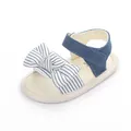 Detailansicht der Baby-Sommersandale mit blauem Denim-Riemen und gestreifter Schleife - Weiß
