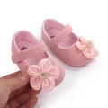 Gedetailleerde weergave van roze baby-loopschoenen met een delicate stoffen bloemendecoratie - Roze