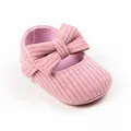 Detailaufnahme eines rosa gestrickten Baby-Prinzessinenschuhs mit einer weichen Schleife - Innenlänge 13cm / Schleife-Stil / Rosa