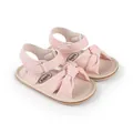 Detailed view of pink baby sandals with decorative bow and adjustable velcro strap - 11cm / Pink