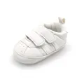 Close-up of white baby walking shoes with anti-slip rubber soles and velcro straps - White