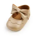 Close-up of gold baby walker shoe with a large bow and soft PU leather texture. - 11cm / Gold