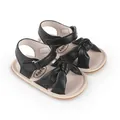 Close-up view of black baby walking sandals featuring a soft bow-knot and velcro straps - 11cm / Black