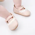 Nahaufnahme von rosa Baby-Lauflernschuhen mit geflochtenen Riemen und Wellenrand. - Rosa