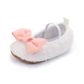 Detalle de zapato de bebé blanco de felpa con un lazo rosa suave y correa elástica - Blanco