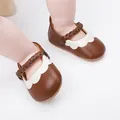 Detailansicht brauner Baby-Lauflernschuhe mit weißem Wellenrand und geflochtenem Riemen - Kaffeebraun
