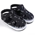 Close-up of black baby walking sandals with white anchor print and velcro strap - Black