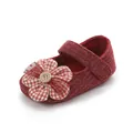 Primo piano dettagliato di una scarpina rossa in maglia con fiore e dettaglio bottone - Lunghezza Interna 11cm / Rosso