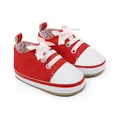 Detailed view of stylish red canvas baby walking shoes featuring pink ribbon laces and white toes - 11cm / Red