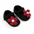 Gros plan de chaussures de princesse bébé tricotées noires avec un grand ornement de fleur rouge - Noir Rouge Grosse Fleur