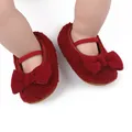 Detail showing the soft red plush texture and bow design of infant walking shoes - Red