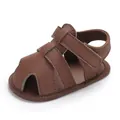 Gros plan sur des sandales bébé en cuir PU marron avec bout fermé protecteur souple - Marron