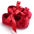 Gros plan sur la texture velours rouge et les nœuds en ruban satin des chaussures bébé - 11CM Longueur de la Semelle / Rouge