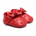Close-up of red baby princess walker shoes with heart embroidery and bow detail - 11cm / Red