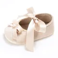 Detailansicht der champagnerfarbenen Babyschuhe mit Satinband, Samtstruktur und Schleife - Aprikose