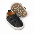 Detail view of black faux leather infant sneakers with non-slip patterned soles. - 11cm / Casual Style (2150) / Black