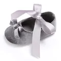 Detailansicht eines grauen Samt-Babyschuhs mit einer großen, weichen Satin-Schleife - Silber