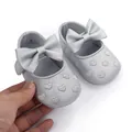 Macro view of silver baby princess walker shoes with embroidered hearts and a large bow. - Silver