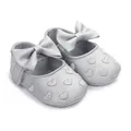 Macro detail of silver baby girl walker shoes featuring a bow and heart embroidery. - Silver