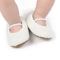 Detailed view of white fuzzy plush baby shoes with elastic strap and soft brown sole - White