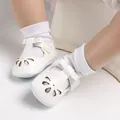 Dettaglio di scarpine bianche per neonato con fiocco e motivi a fiori traforati. - 11cm / Bianco
