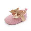 Detalle de zapatos de punto rosa para bebé con un gran lazo de satén dorado - Rosa