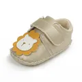 Detail van gouden babyloopschoen met schattig leeuwenontwerp en stevig klittenband - Goud