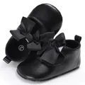 Vista detallada de elegantes zapatos negros para caminar de bebé con lazos decorativos - Negro