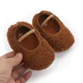Dettaglio di scarpine da bambino in pile marrone con cinturino elastico morbido. - Caffè