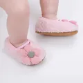 Detailansicht weicher rosa Plüsch-Babyschuhe mit einer dekorativen Blume vorne - Rosa