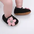 Nahaufnahme von schwarzen Plüsch-Babyschuhen mit weicher Sohle und rosa Blüte - Schwarz