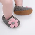Detaillierte Nahaufnahme grauer Babyschuhe mit einer großen rosa Blumenverzierung. - Grau