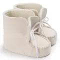 Dettaglio di scarpe da bambino bianco sporco con morbida fodera in finta pelle di pecora - Bianco