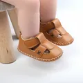 Detailed view of brown faux leather baby sandals with Velcro straps and cross design - Apricot
