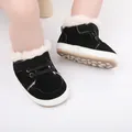 Nahaufnahme schwarzer Winter-Babyschuhe mit warmem weißem Kunstfellfutter - Schwarz