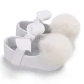 Gros plan de chaussures blanches pour bébés filles avec de grands pompons et nœuds - Blanc