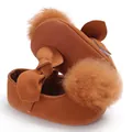 Détail de chaussures de princesse pour bébé avec pompon en fourrure et semelle antidérapante - Marron