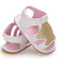 Detailbeeld van witte en roze babysandalen voor meisjes met gouden glitter kroon decoratie. - Goud