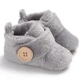 Detailed close-up of grey plush baby booties with wooden button and soft fleece texture - Gray