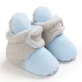 Primer plano de botas de nieve para bebé de forro polar azul con forro de piel sintética gris. - Azul claro