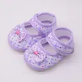 Draufsicht auf lila karierte Babyschuhe mit Blumenmuster und rosa Schleife. - Lila
