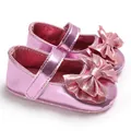 Détail de la finition rose métallisé et du grand nœud sur ces chaussures de princesse bébé - Rose