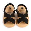Vista de detalle de sandalias para bebé con correas cruzadas negras y suela beige - Negro / 12 cm / 42 g
