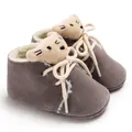 Primer plano de zapatos de invierno para bebé con forro de felpa y detalle de oso - Gris