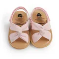 Primer plano de sandalias rosas para bebé con un diseño decorativo de nudo cruzado. - Rosa / 12 cm / 42 g